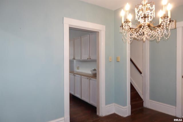 hallway featuring dark hardwood / wood-style floors and a notable chandelier