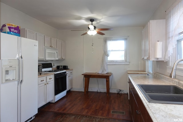 kitchen with ceiling fan, sink, white appliances, white cabinets, and dark hardwood / wood-style flooring