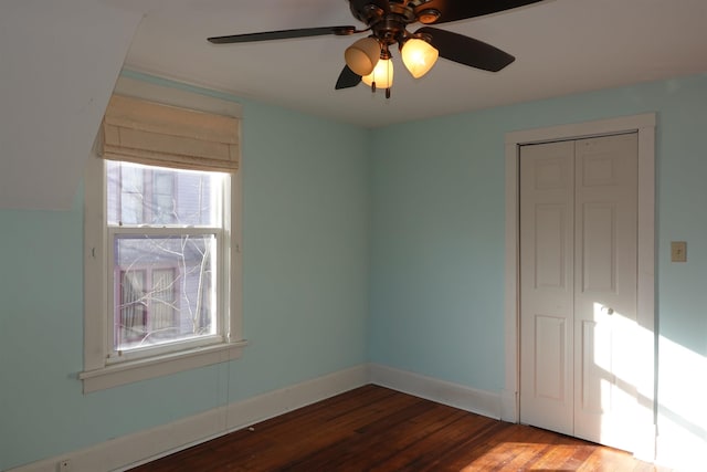 unfurnished bedroom with ceiling fan, a closet, and hardwood / wood-style floors