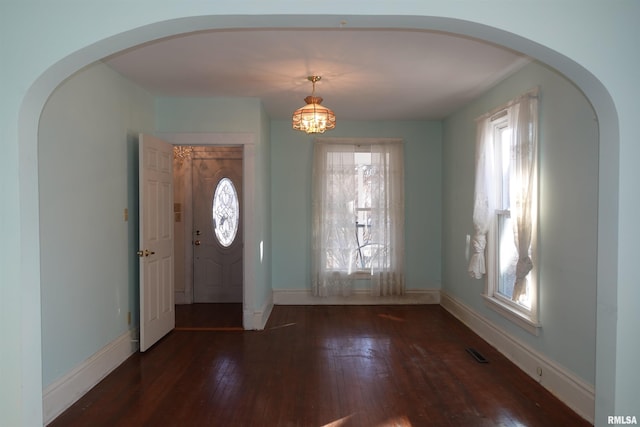 foyer featuring dark hardwood / wood-style flooring and a chandelier