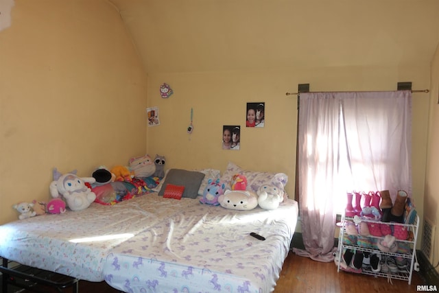 bedroom with wood-type flooring and vaulted ceiling