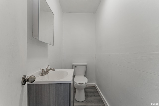 bathroom featuring toilet, vanity, and wood-type flooring