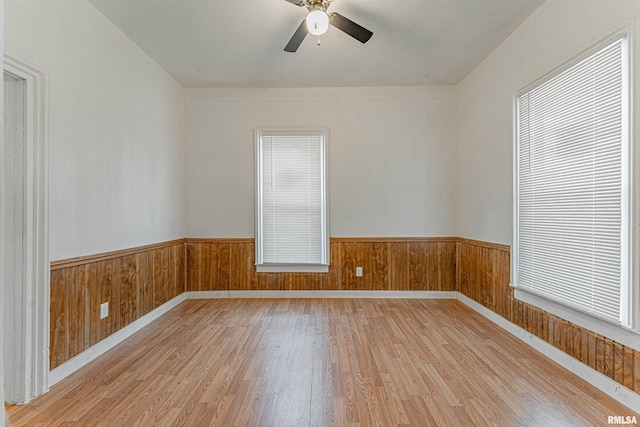 empty room with ceiling fan, light hardwood / wood-style floors, and plenty of natural light