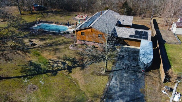 rear view of property with a lawn, an outdoor fire pit, solar panels, and a wooden deck