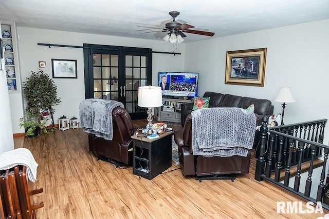 living room featuring wood-type flooring, ceiling fan, and french doors