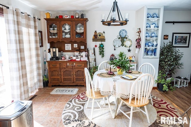 dining area featuring a notable chandelier and light tile patterned flooring