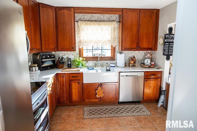 kitchen with stainless steel appliances, sink, light tile patterned floors, and decorative backsplash