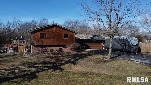 view of side of home featuring a garage, a yard, and a deck