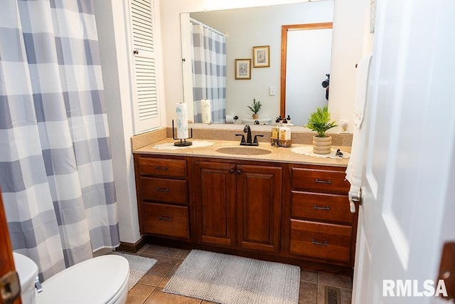 bathroom featuring toilet, tile patterned floors, and vanity