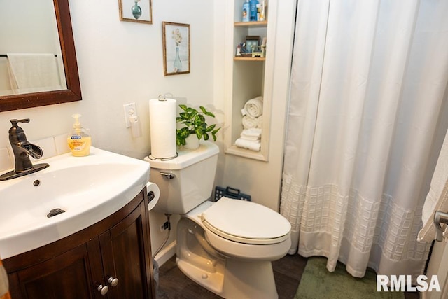 bathroom with vanity, toilet, and hardwood / wood-style floors