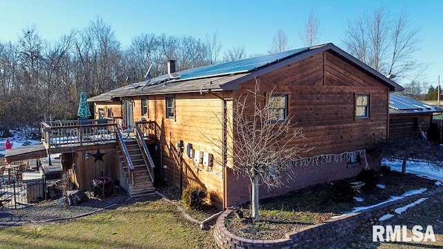 view of side of home featuring a deck and solar panels