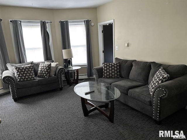 living room with baseboard heating, a wealth of natural light, and dark colored carpet