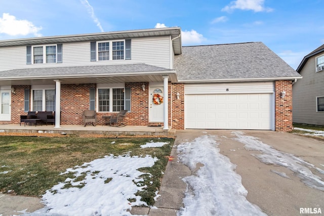 view of property with a garage, a yard, and covered porch