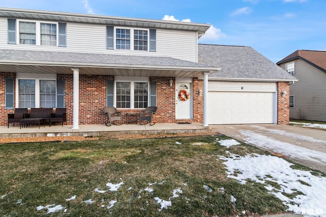 front of property with a garage, a lawn, and covered porch