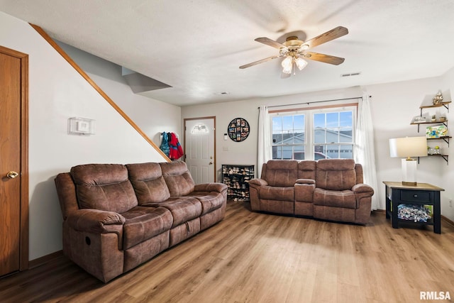 living room featuring ceiling fan and light hardwood / wood-style flooring