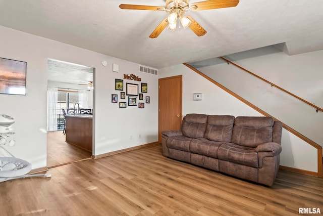 living room with light hardwood / wood-style flooring and ceiling fan