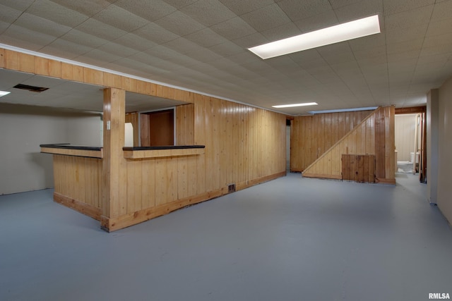 basement with wood walls and bar area