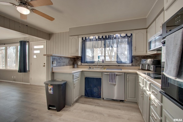 kitchen featuring stainless steel dishwasher, backsplash, black double oven, and light hardwood / wood-style flooring