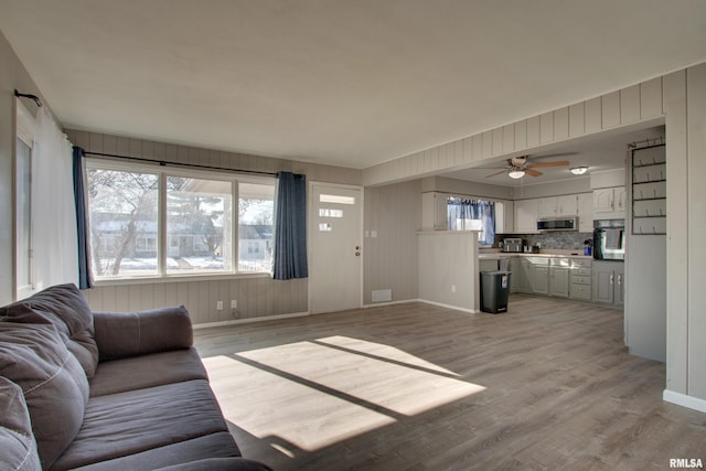 living room with ceiling fan and light hardwood / wood-style flooring