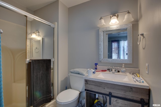 bathroom featuring a shower with door, toilet, and vanity