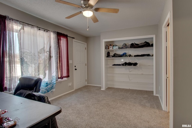 home office featuring ceiling fan, light colored carpet, a textured ceiling, and a healthy amount of sunlight