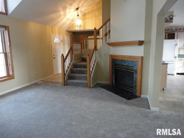 unfurnished living room featuring light colored carpet and vaulted ceiling