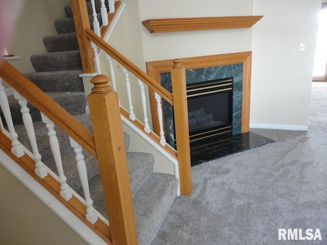 staircase with carpet floors and a fireplace