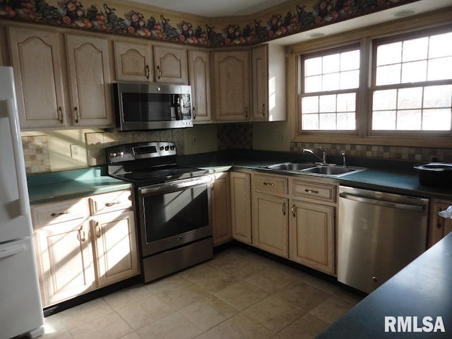 kitchen with sink, appliances with stainless steel finishes, tasteful backsplash, and light tile patterned flooring