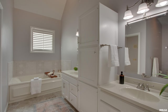 bathroom featuring lofted ceiling, vanity, and a tub to relax in