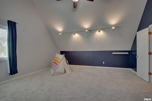 recreation room featuring lofted ceiling, track lighting, and light colored carpet