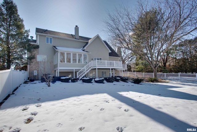 snow covered property with a wooden deck