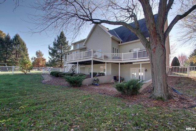 rear view of house with a wooden deck and a yard