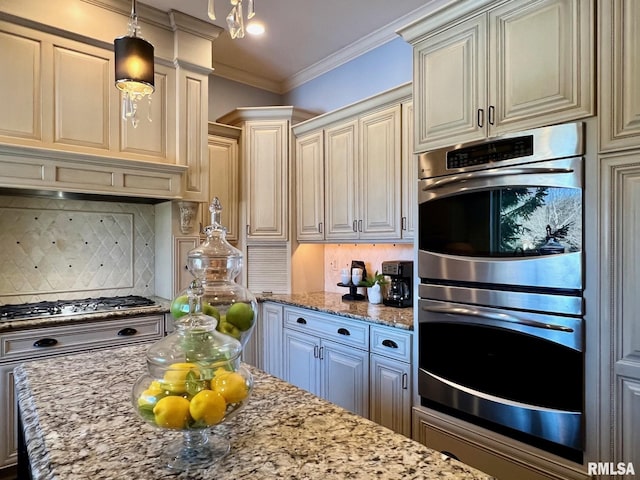 kitchen with appliances with stainless steel finishes, backsplash, light stone counters, and decorative light fixtures