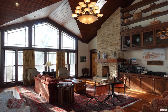 living room featuring a stone fireplace, wooden ceiling, hardwood / wood-style flooring, high vaulted ceiling, and an inviting chandelier