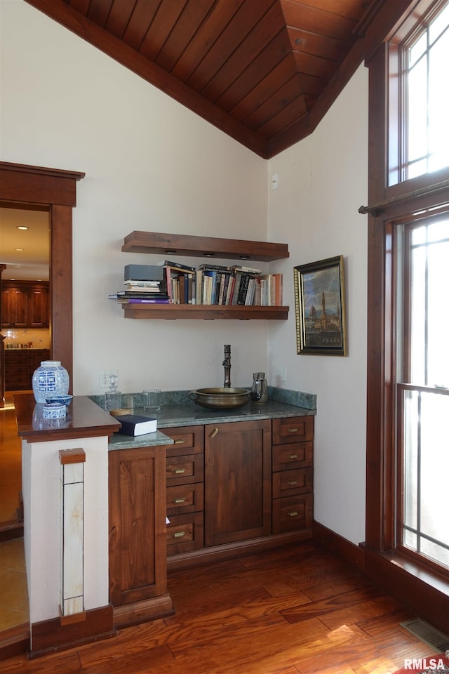 bar with dark hardwood / wood-style flooring, lofted ceiling, wood ceiling, and a healthy amount of sunlight