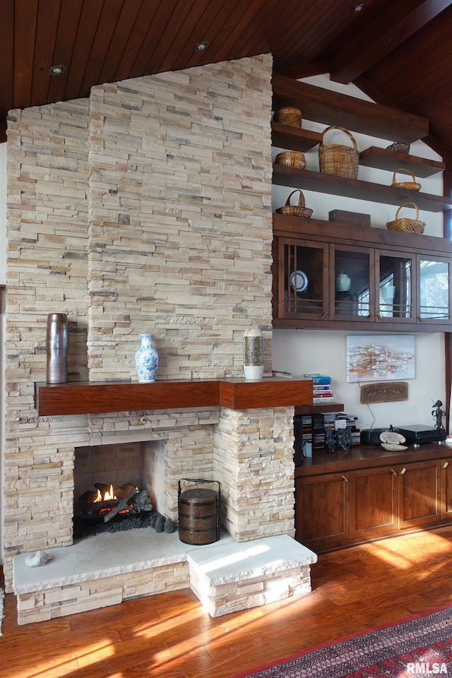 bar featuring wood-type flooring, lofted ceiling with beams, a stone fireplace, and wood ceiling