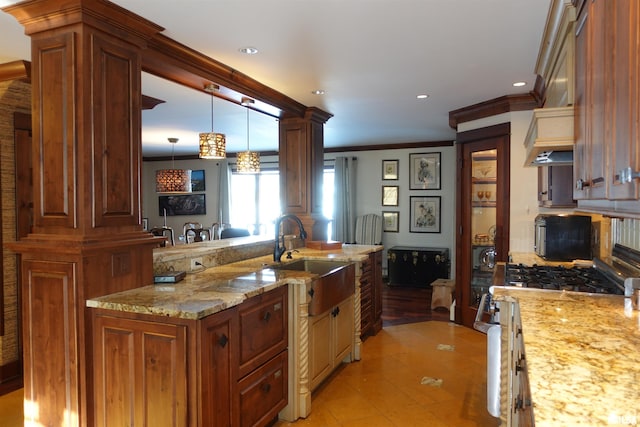 kitchen featuring light stone countertops, pendant lighting, sink, ornamental molding, and light tile patterned flooring