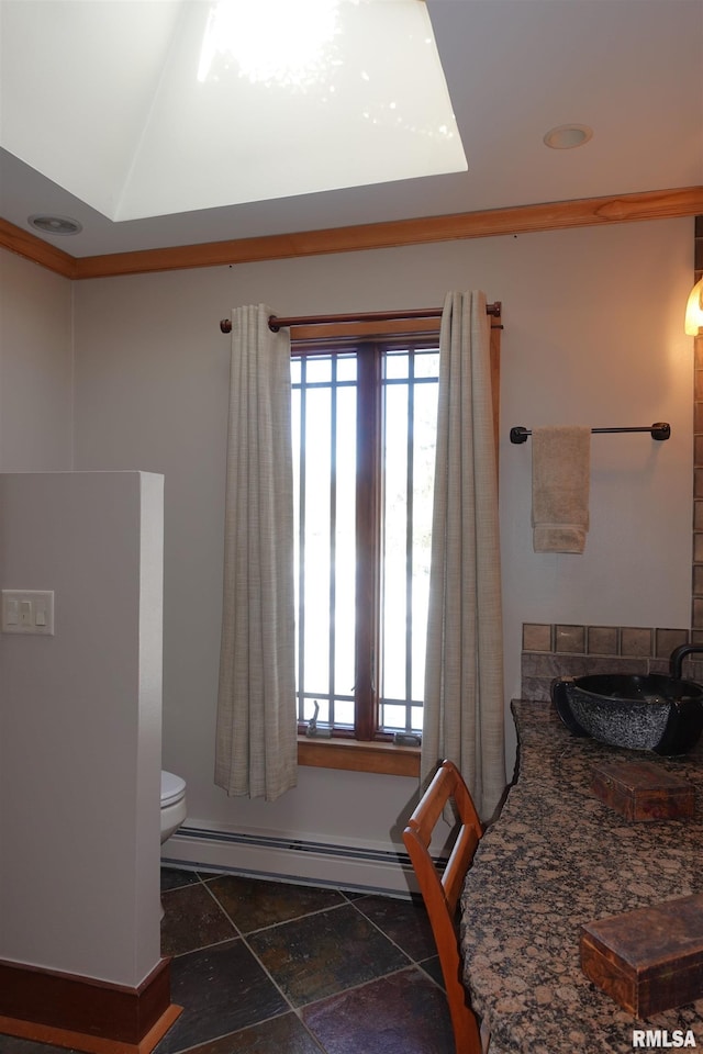 bathroom featuring a baseboard heating unit and toilet