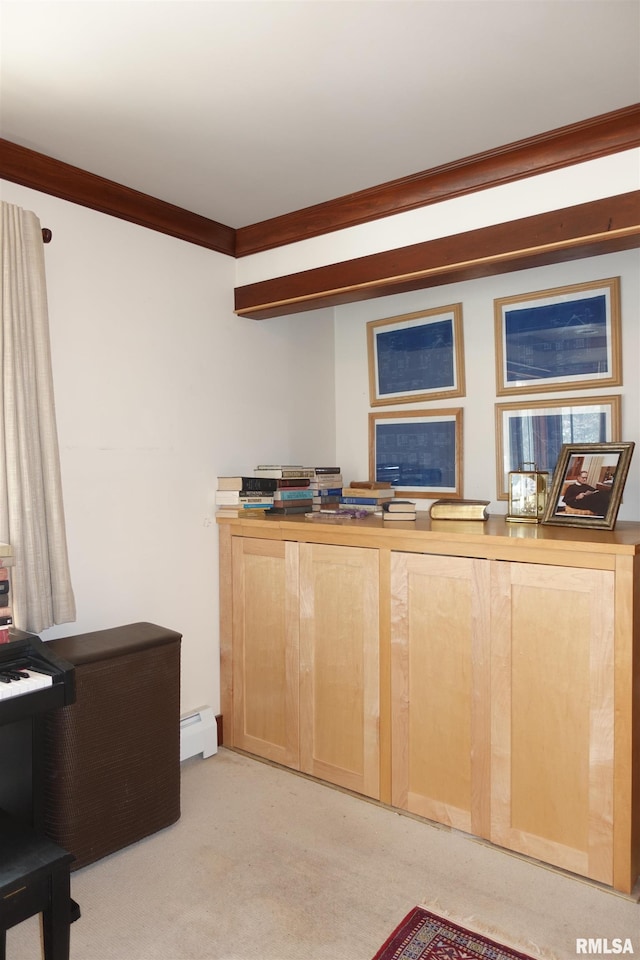 kitchen featuring light brown cabinetry, baseboard heating, light carpet, and crown molding