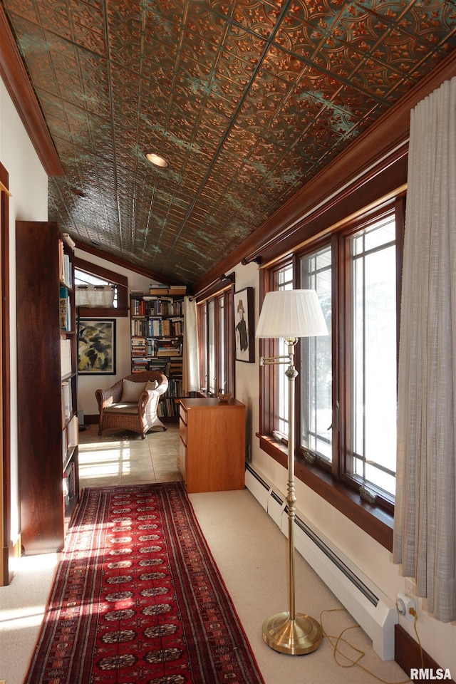 hallway with carpet flooring, brick ceiling, a baseboard heating unit, and ornamental molding