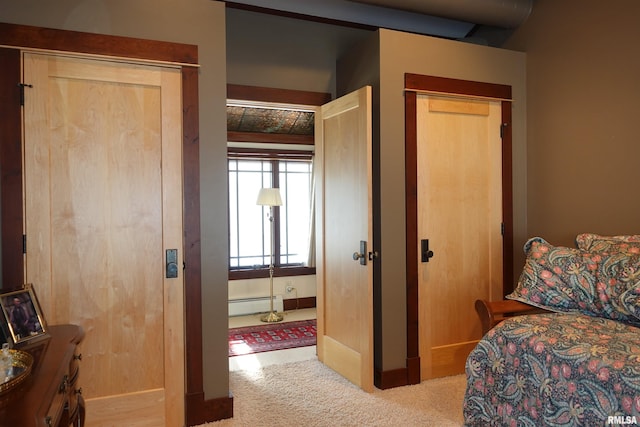 carpeted bedroom with baseboard heating and a closet