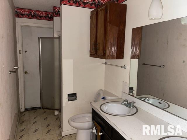 bathroom with vanity, toilet, and a textured ceiling