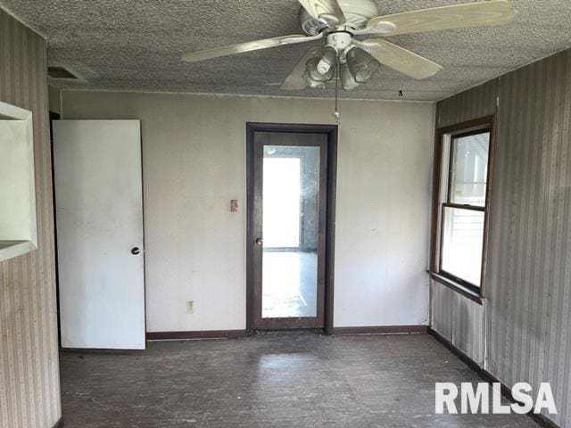 empty room with wooden walls and ceiling fan