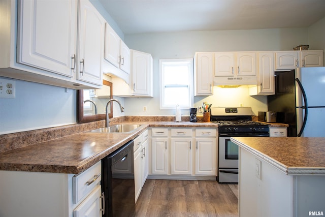 kitchen with white cabinets, appliances with stainless steel finishes, light hardwood / wood-style flooring, and sink