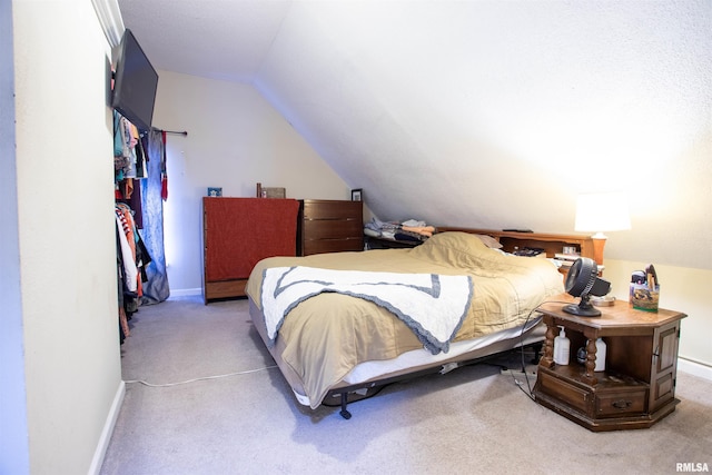 bedroom featuring carpet and vaulted ceiling