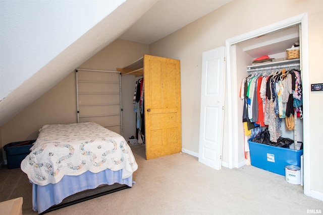 carpeted bedroom with a closet and vaulted ceiling