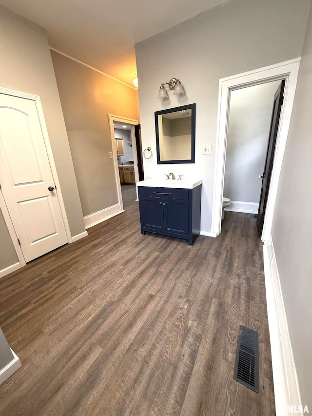 interior space featuring vanity, hardwood / wood-style flooring, and toilet