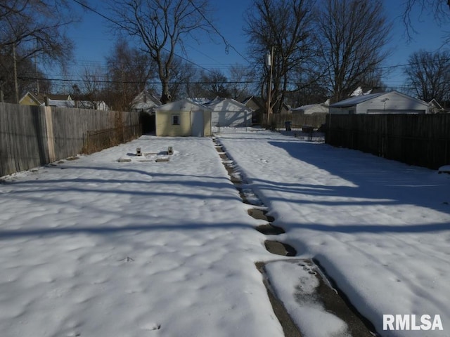 yard covered in snow featuring a storage unit