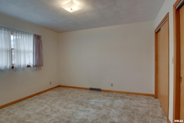 unfurnished bedroom with a closet and light colored carpet