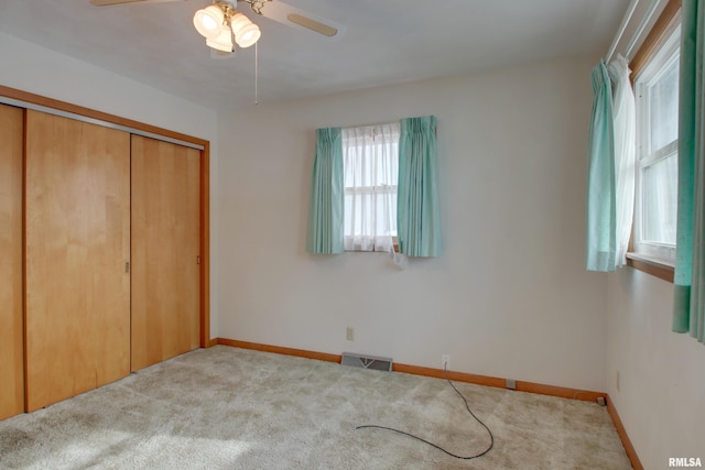 unfurnished bedroom with carpet floors, a closet, and ceiling fan